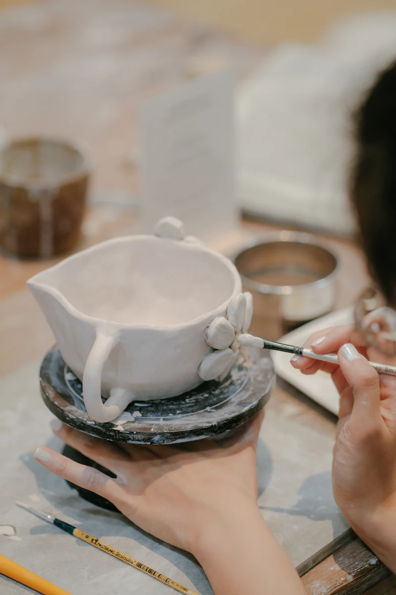 A small white piece being painted with a fine brush