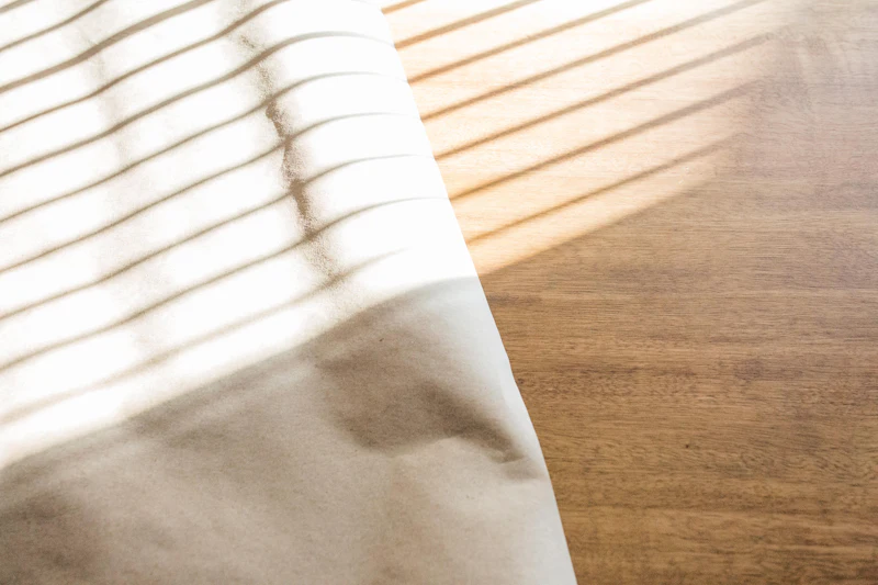 Morning light falling across linen on a wooden floor